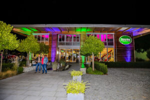Das farbig beleuchtete Forst-Kompetenzzentrum sorgt für eine besondere Atmosphäre bei der Unterreiner-Night. Bild: Unterreiner GmbH
